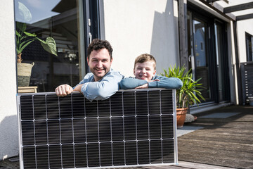 Father and son enjoying quality time with a solar panel outdoors