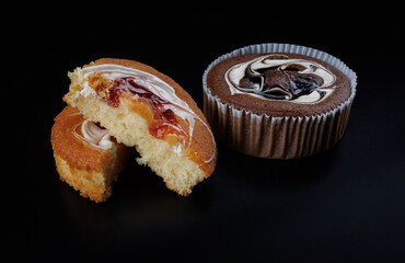 Sliced and whole cake on black background.