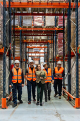 Warehouse manager and workers inspecting inventory in logistics facility
