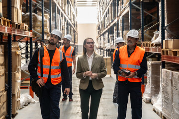 Logistics managers and workers inspecting goods in modern warehouse