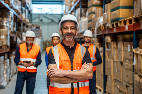 Logistics manager smiling with warehouse team - Powered by Adobe