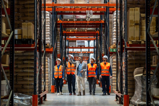 Warehouse manager leading team through logistics facility - Powered by Adobe