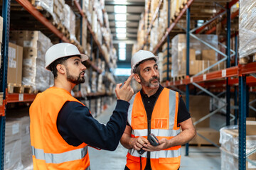 Warehouse workers checking inventory and discussing logistics operations