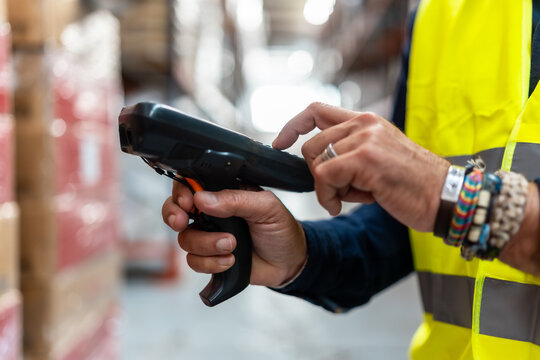 Warehouse worker scanning barcode on products for inventory management