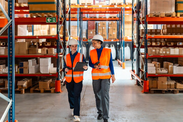 Women workers checking inventory walking in logistics warehouse