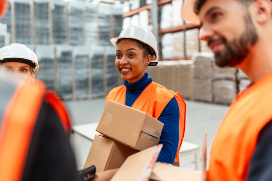 Warehouse workers collaborating picking orders for shipping - Powered by Adobe