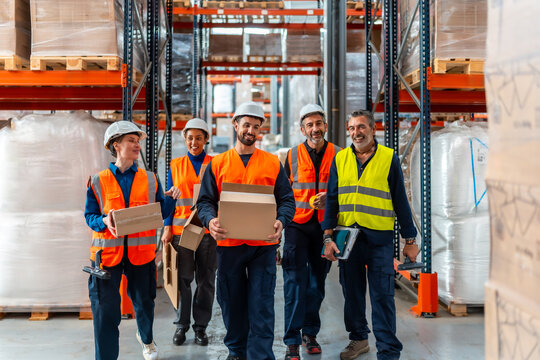 Logistics team workers carrying boxes in warehouse