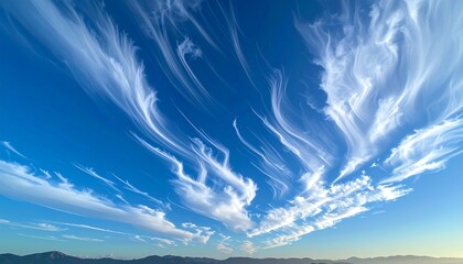 Bright blue sky filled with thin, wispy cirrus clouds streaking across the horizon, fading from lighter to deeper hues