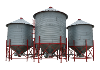 Isolated metal grain bins storing grain on a farm, red support structures, ladders, silver color
