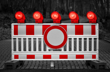 Traffic barring with red battery flash lights indicating road closure, “no entry“ or “do not pass“ at a blocked road. Colorful elements isolated on black and white dark grayscale background.