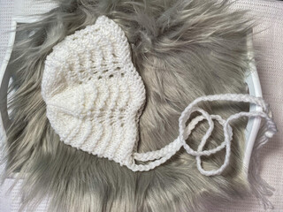 hand knitted baby bonnet with fan and feather stitch pattern, example of hand knitting 
