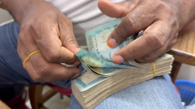 Man Counting Bangladeshi Taka Banknotes &mdash; Financial Transaction and Economy Concept