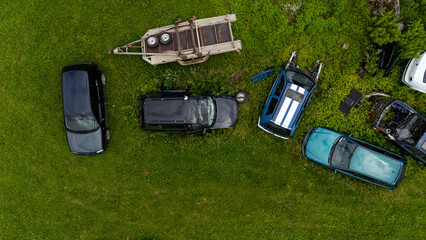 Old cars and a truck abandoned in green field during the day