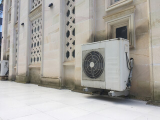 Exterior Architecture and Air Conditioning Units: A facade of a building showcasing stone carvings and an industrial air conditioning unit.
