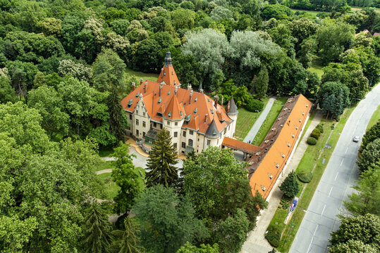 Aerial view of the majestic Mailath Castle with its striking orange roof and ornate turrets, nestled among the lush greenery, Donji Miholjac, Osijek-Baranja County, Croatia.