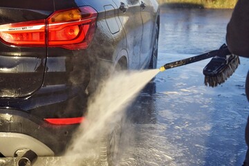 A man washes his car at a self-service station.