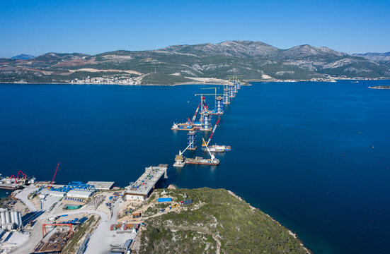 Aerial view of the Peljesac Bridge construction site over the shimmering blue waters, a testament to human engineering, Brijesta, Dubrovnik-Neretva County, Croatia.