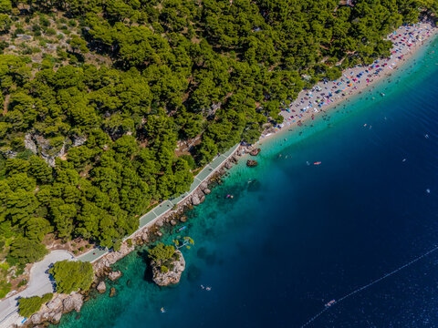 Aerial view of Punta Rata beach with its vibrant turquoise water contrasting with the deep blue sea, Brela, Split-Dalmatia County, Croatia.