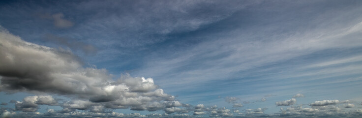 Obraz premium Beautiful wide panorama of various cloud types filling vast blue sky with copy space