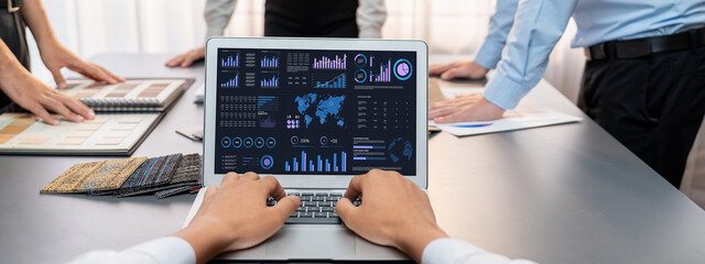 Group of interior architect designer team at table choosing various mood board samples with architecture software on laptop screen. Modern renovation and interior material selection concept. Insight