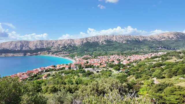 Panoramic aerial view of scenic coastal town with vibrant blue sea and mountain backdrop. Ba&scaron;ka, Krk island, Croatia