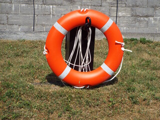 A close-up photograph of an orange life preserver likely located near a body of water or a lock system.
