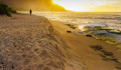 Female Tourist Walking on The Shoreline of Kaena Point State Park at Sunset ,Oahu, Hawaii, USA