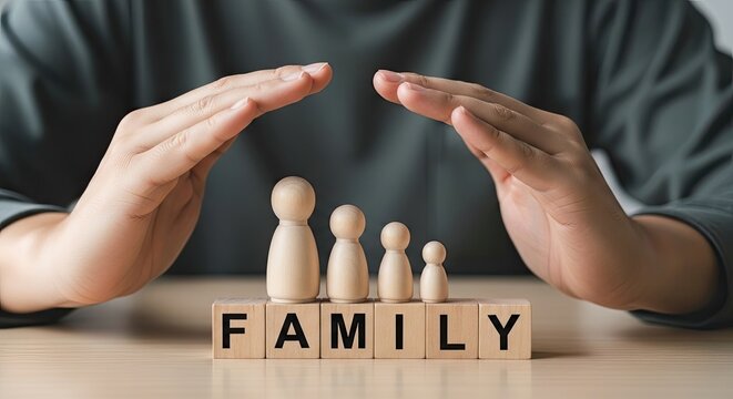 Hands protecting family wooden figures and word blocks for security