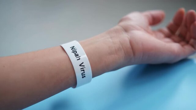 Close up of wristband labeled Nipah Virus on human arm, medical identification, infectious disease alert, healthcare precaution, patient monitoring, virus outbreak, epidemic warning
