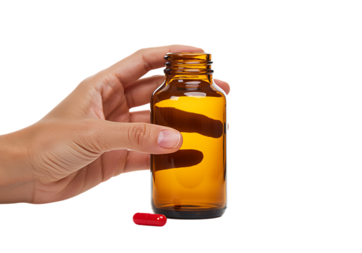 hand holding amber bottle with red pill on transparent background