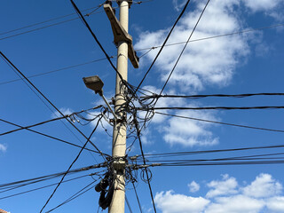 Streetlight and electric wires on concrete pole. Connection, technology, and everyday urban infrastructure.
