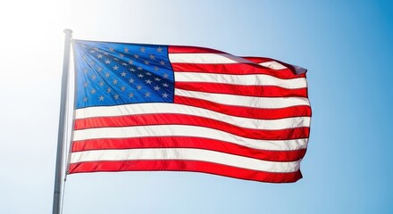Obraz premium Bright and Vibrant American Flag Waves Against Clear Blue Sky with Sunlight Background