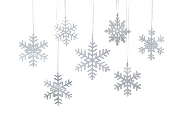 Elegant Silver Snowflake Ornaments Suspended Against a Pristine White Backdrop, Ideal for Holiday Decorations.
