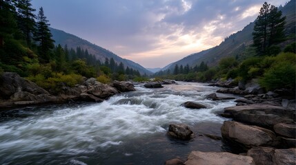 Whitewater river rapids flow through a scenic mountain valley at dusk