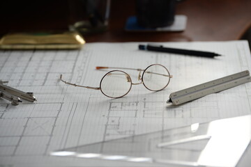 建築士の製図机に置かれた眼鏡と製図道具 Architect’s drafting desk with glasses and drawing tools