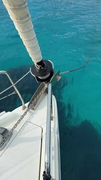 Automatic anchor chain retrieval on a yacht using a remote control during anchoring. Close-up of windlass system in action, detail from modern sailing life and nautical routine