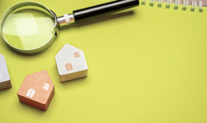 Magnifying glass and miniature houses. House searching concept. Home appraisal. Property valuation....