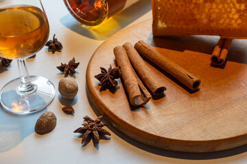 Glass of amber whiskey with rich winter spices, cinnamon, star anise, nutmeg, and honeycomb. Perfect for holiday and spiced drink concepts. Concept of a cozy, spiced cocktail, Christmas spirit