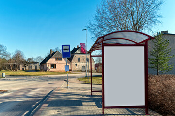 Blank billboard mock-up at a bus stop in a quiet suburban area during daytime