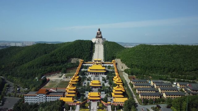 Aerial view of the Golden Buddha statue at Liudingshan Cultural Tourism Area in Dunhua City, Jilin Province, China. Massive golden statue overlooking Zhengjue Temple and facing the Changbai Mountain