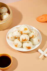 Traditional Chinese Xiaolongbao Soup Dumplings with Carrot Garnish and Bamboo Steamer