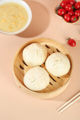 Handmade Steamed Meat Buns in Bamboo Steamer with Fresh Soup and Cherry Tomatoes