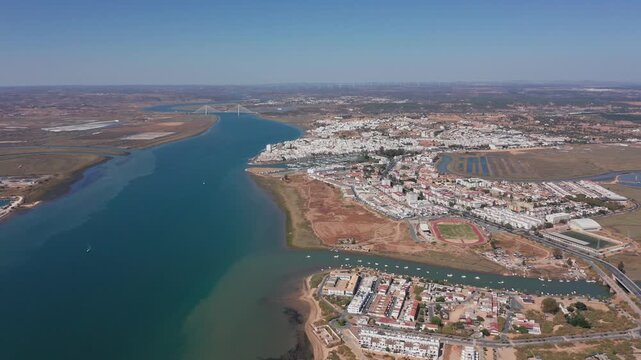 Ayamonte aerial view guadiana river and ayamonte wide river channel cutting through marshy banks urban cluster and sparkling salt pans boat trails highlight active estuarine corridor