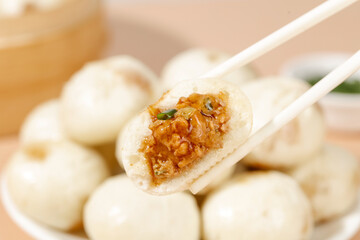 Xiaolongbao Soup Dumplings with Fresh Meat Filling - Traditional Chinese Shengzhou Bao Dumplings Held by Chopsticks