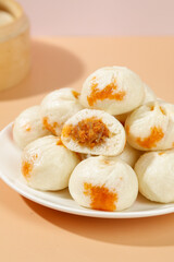 Traditional Xiaolongbao Steamed Dumplings with Orange Filling on White Plate - Chinese Breakfast Food