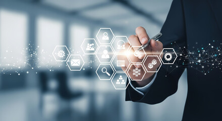 A businessman's hand interacts with holographic technology, showcasing digital icons and symbols, representing innovation and future business strategies.