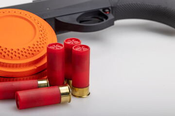 Clay disc flying target and shotgun with bullet shell on white background ,Clay shooting game