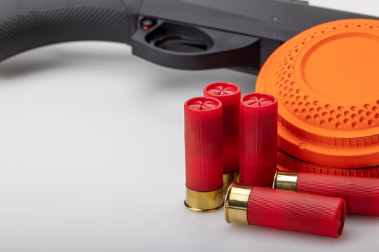 Clay disc flying target and shotgun with bullet shell on white background ,Clay shooting game
