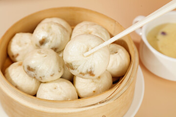 Traditional Chinese Xiaolongbao Steamed Meat Buns in Bamboo Steamer Basket with Chopsticks