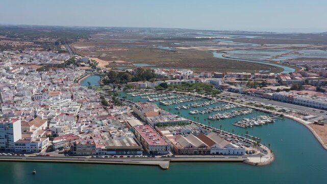 Aerial view drone shot of Ayamonte Overview of port entrance showcasing lively marina and safety barriers, Detailed summary of harbor entry point highlighting vibrant marina